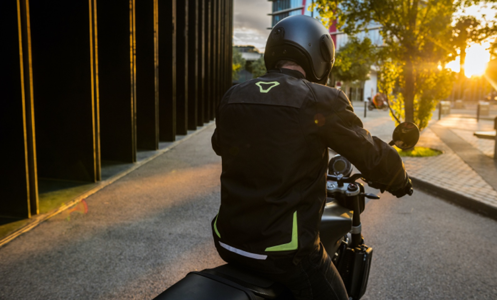 Motorcyklist med macna jakke på set bagfra